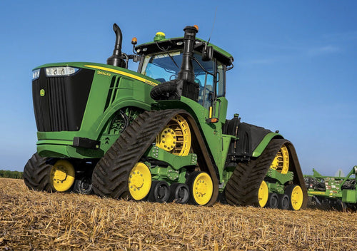 Photo of John deere mit Ketten at a field 