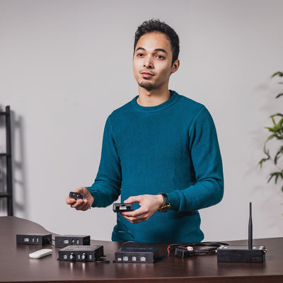 Engineer demonstrating linear actuator control boxes and remotes on desk  