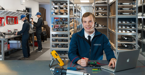 Progressive Automations team member providing technical support in warehouse with linear actuators and components